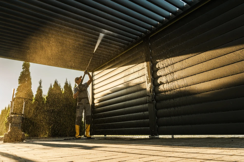 Des hommes avec lave-linge sous pression nettoient sa pergola en aluminium résidentiel
