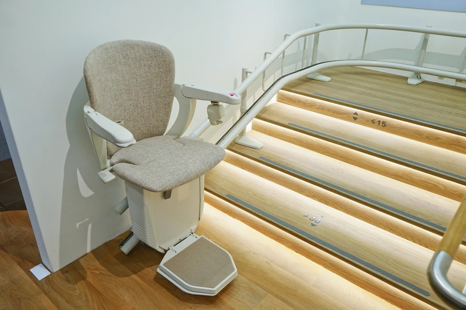 Intérieur résidentiel moderne avec monte-escalier courbe installé le long d'un escalier en bois clair