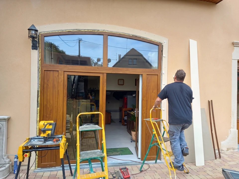 Homme mesurant la fenêtre avant l'installation du volet roulant à l'extérieur